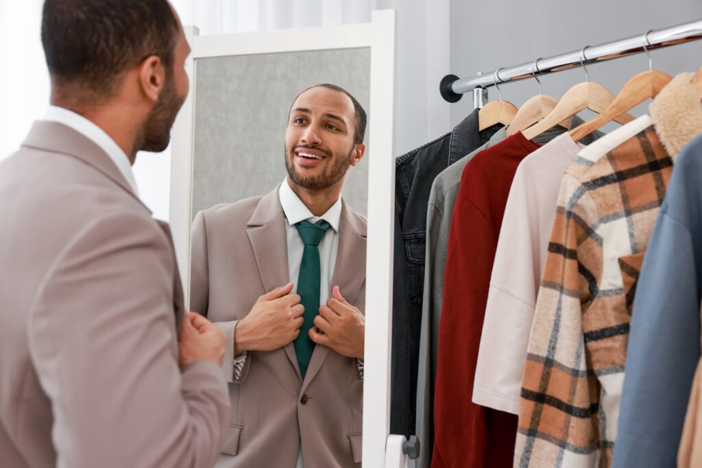 Smiling man looking at mirror at home